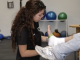 A student Athletic trainer wraps a person left ankle with tape in a training room at Canyon High School
